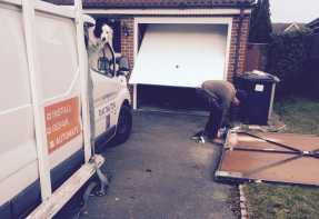 dog overseeing its humans installing a garage door